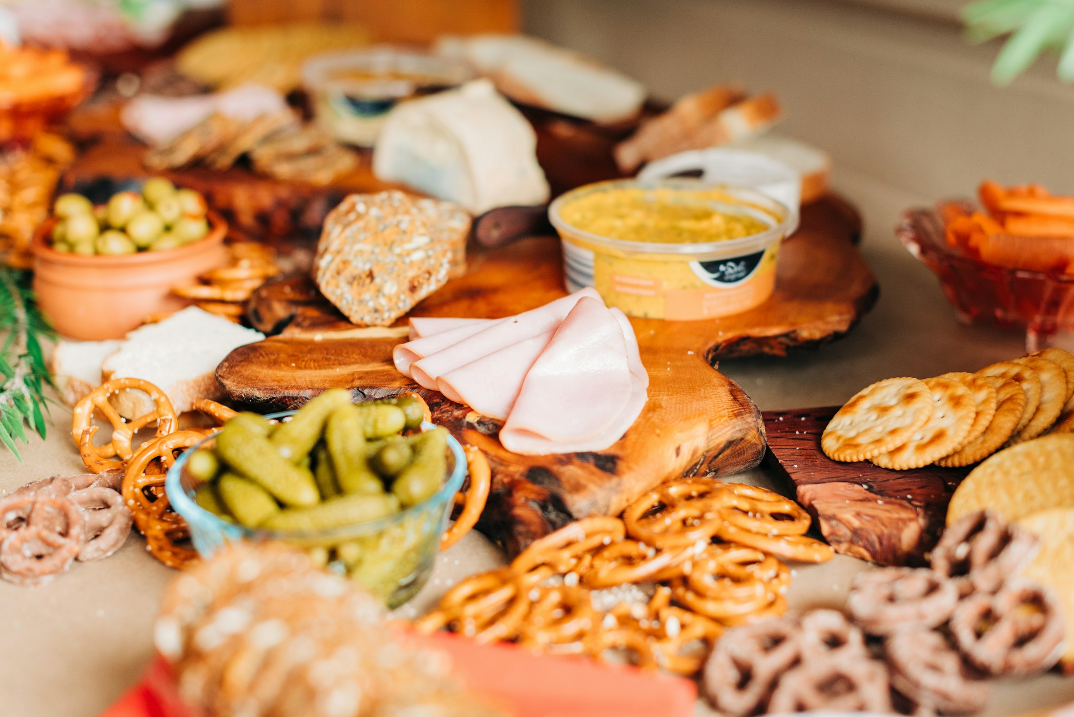 An overhead view of a beautifully styled grazing table with cheeses, charcuterie, fruit, and herbs.